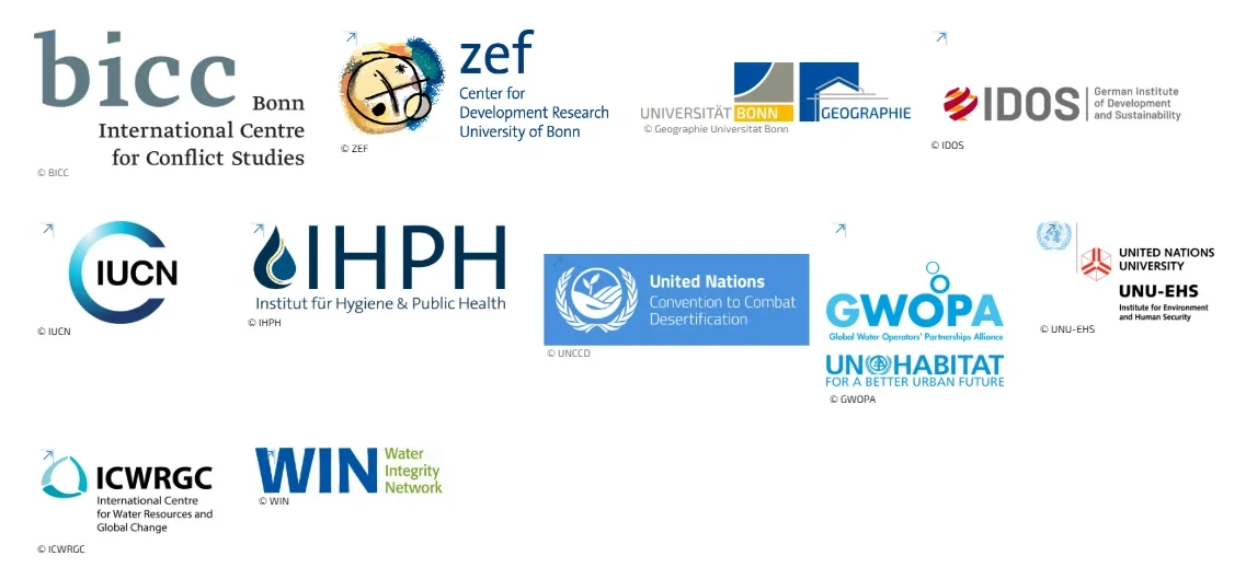 Eine Wissenschaftlerin und ein Wissenschaftler arbeiten hinter einer Glasfassade und mischen Chemikalien mit Großgeräten.