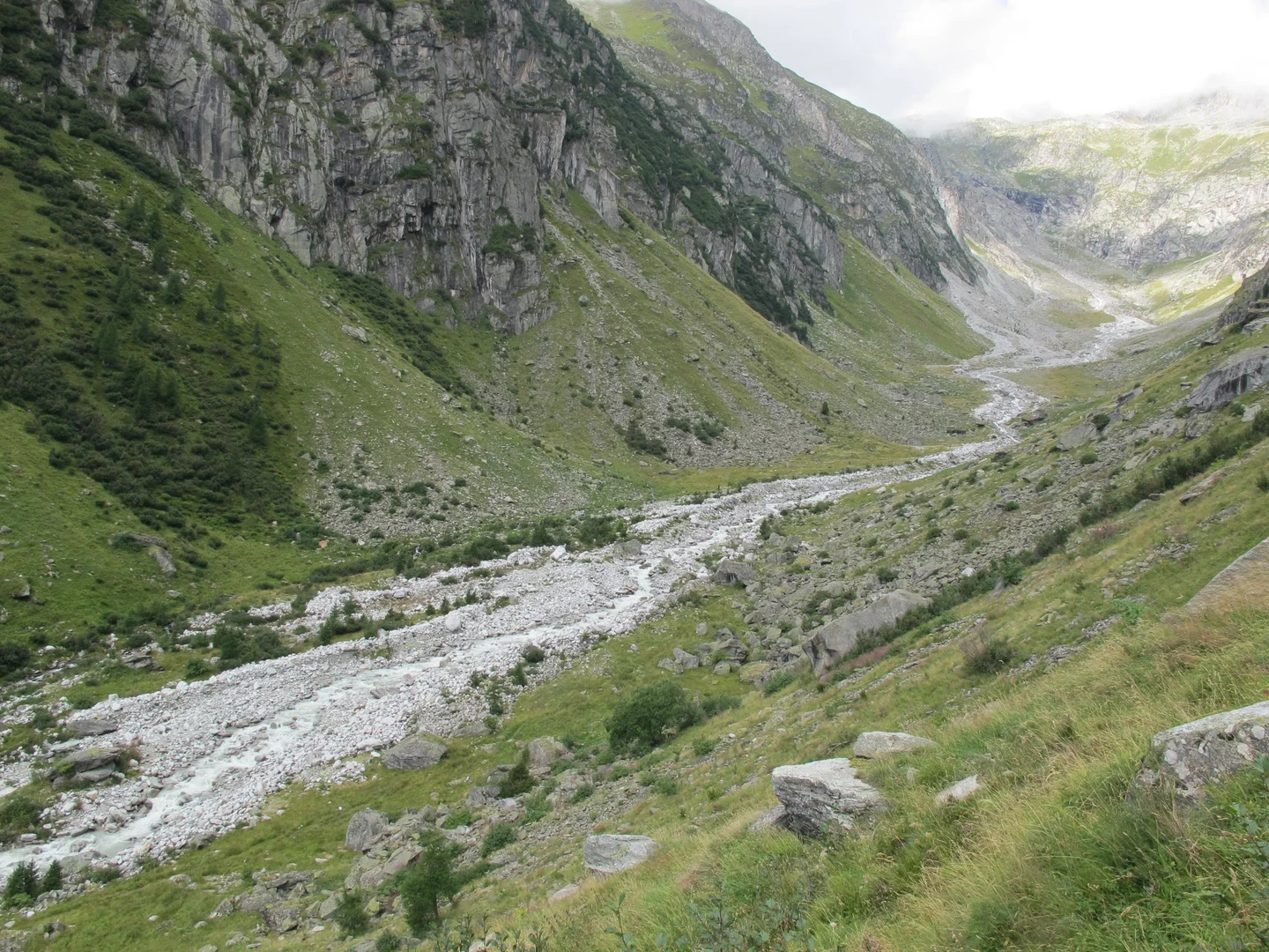 Eine Wissenschaftlerin und ein Wissenschaftler arbeiten hinter einer Glasfassade und mischen Chemikalien mit Großgeräten.