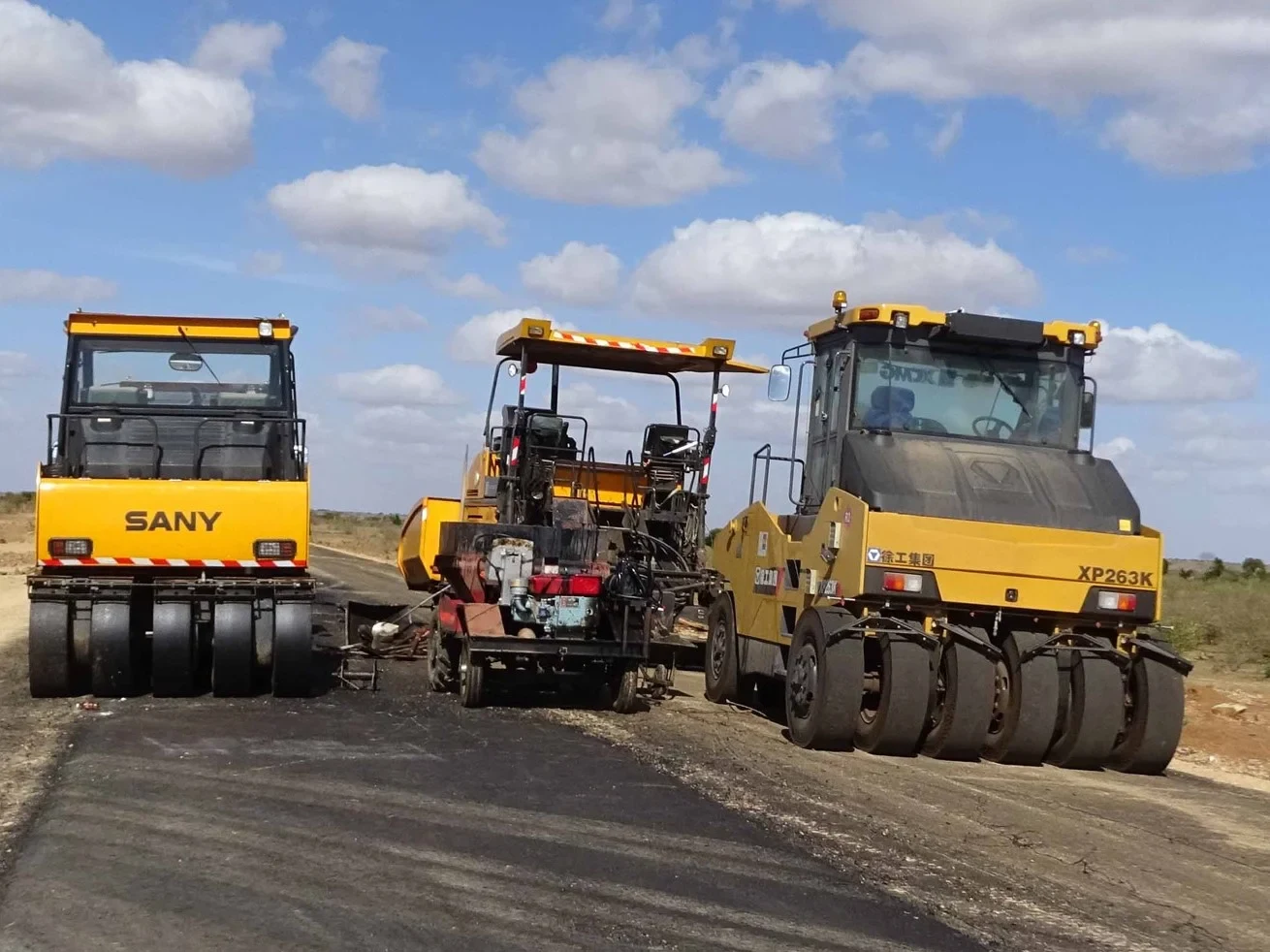 Zwei gelbe Bagger, die eine Straße in Kenia erneuern