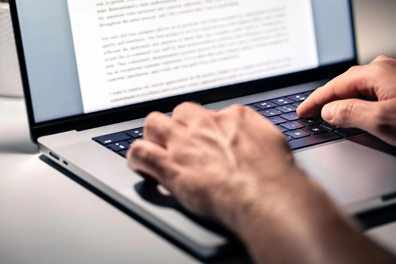 Eine Person tippt einen Text auf einem Laptop