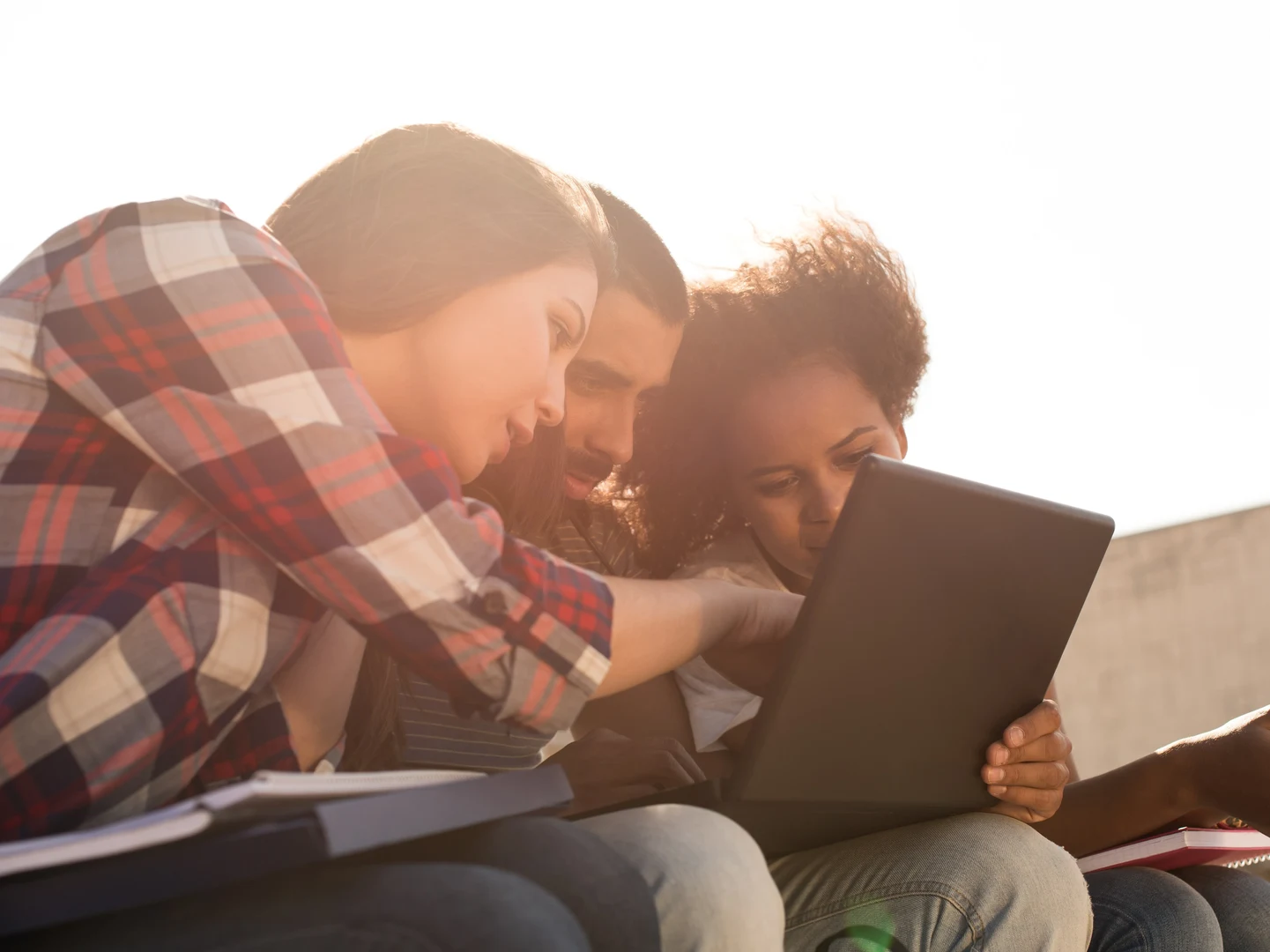 Eine Wissenschaftlerin und ein Wissenschaftler arbeiten hinter einer Glasfassade und mischen Chemikalien mit Großgeräten.