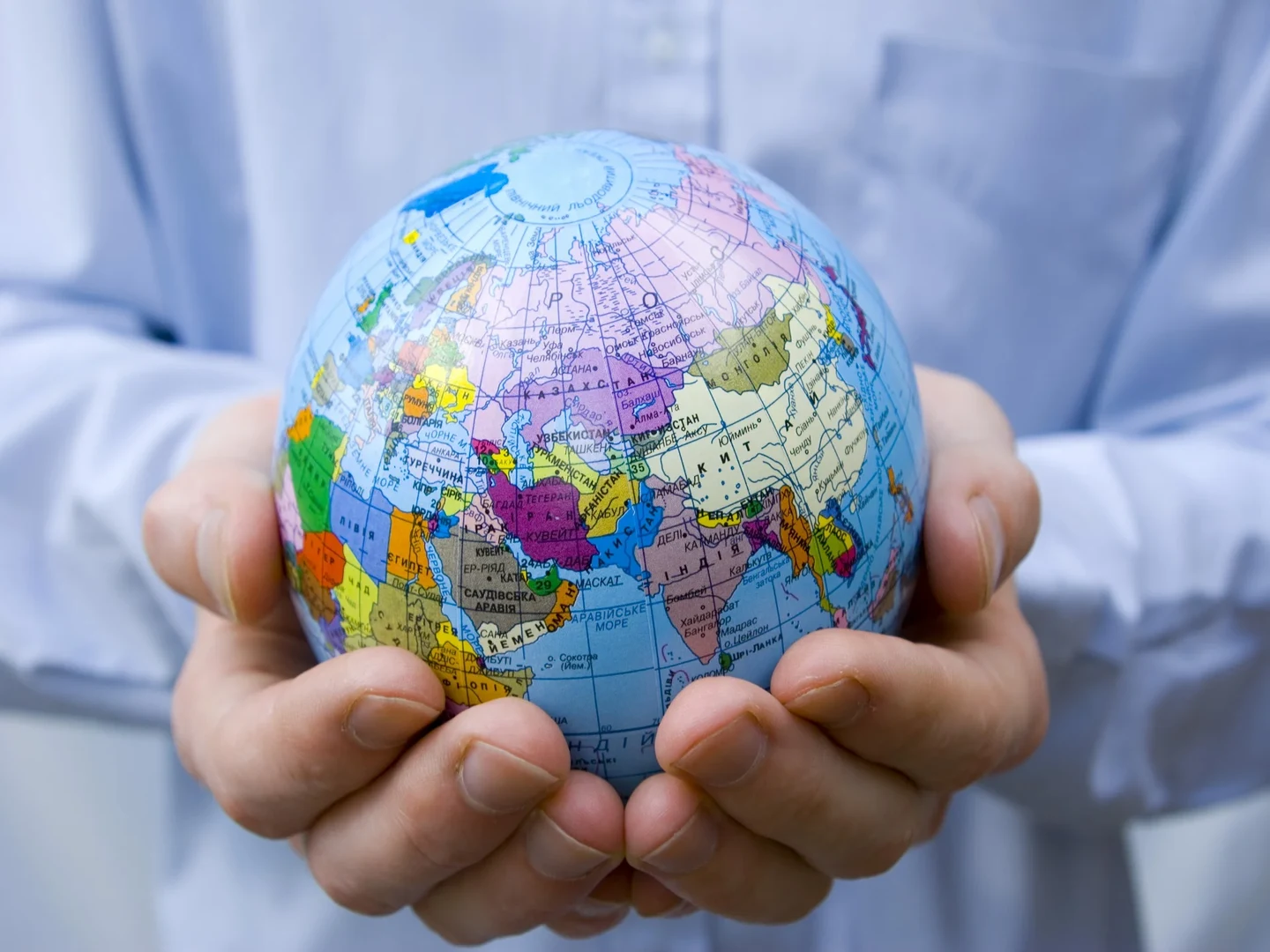Eine Weltkugel wird in zwei Händen gehalten