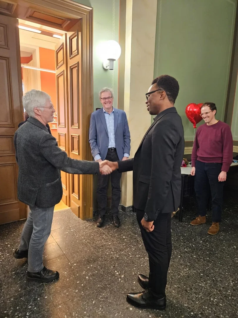 Phillip Garjay Innis shaking hands with his supervisor just after the closed deliberation of the doctoral committee